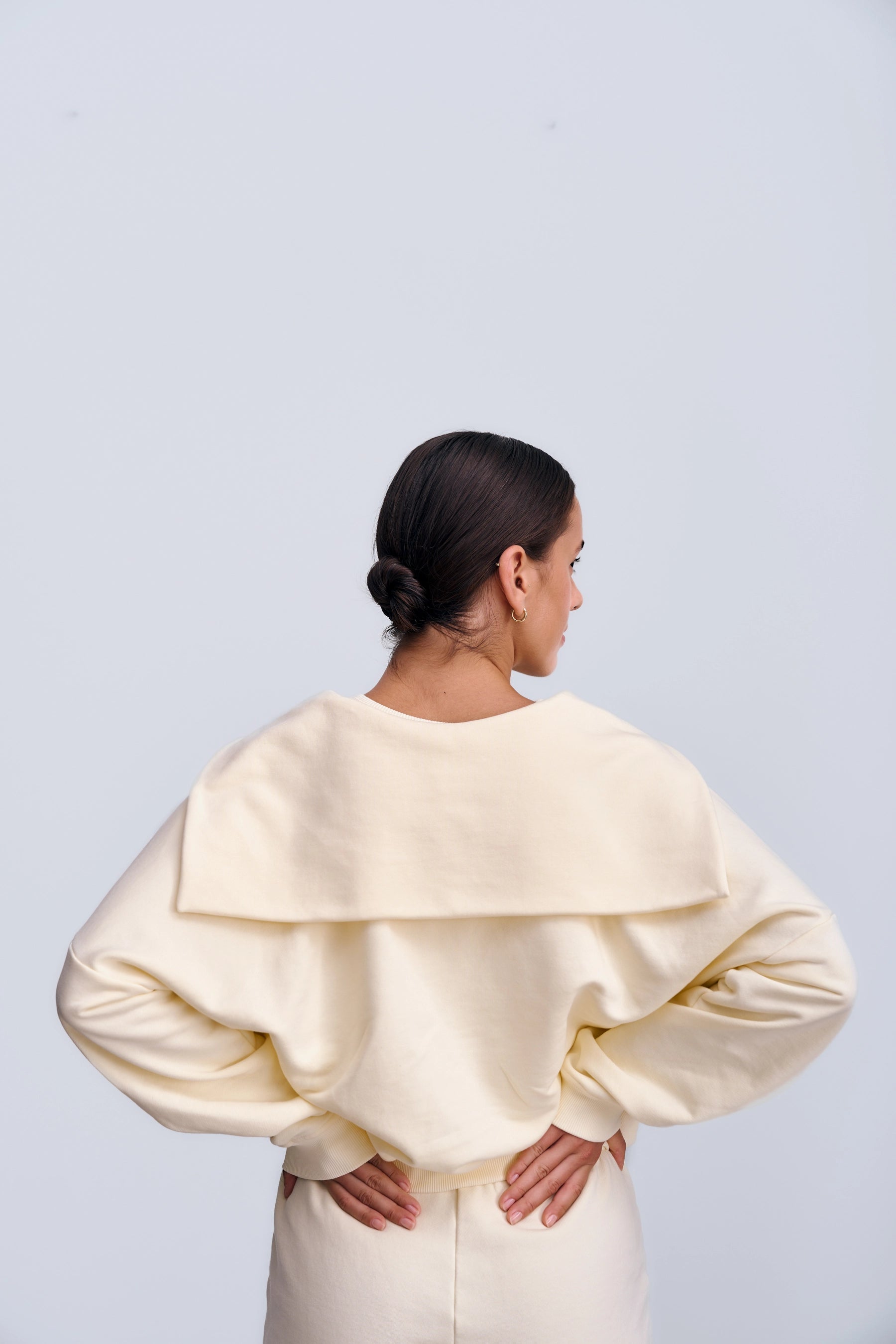 Tył Capri Sweatshirt Butter Yellow – minimalistyczna żółta bluza o skróconym kroju i gładkim wykończeniu materiału.