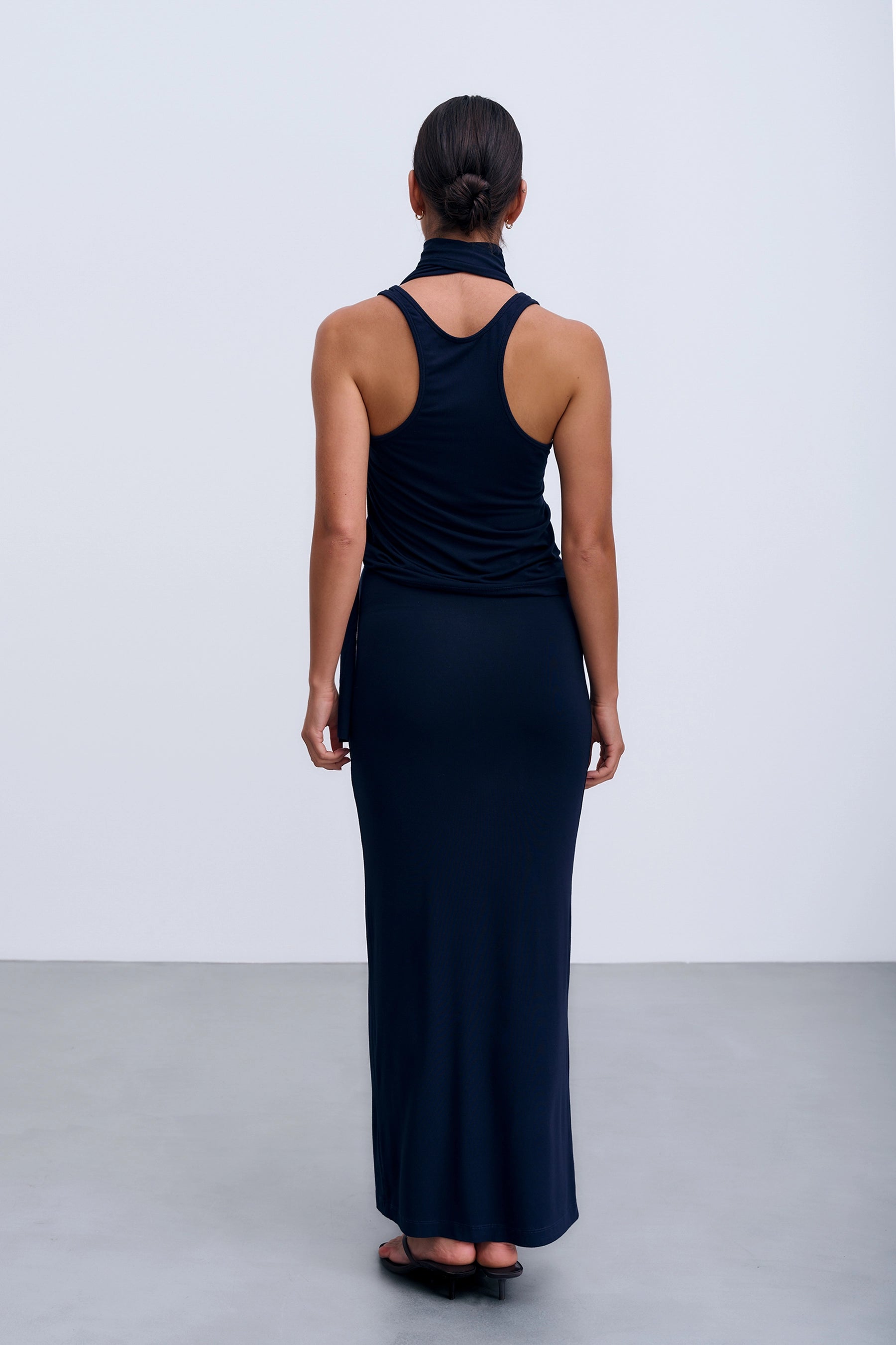 Tył Roma Skirt – granatowa spódnica maxi z elastyczną talią, o gładkiej powierzchni i minimalistycznym designie.