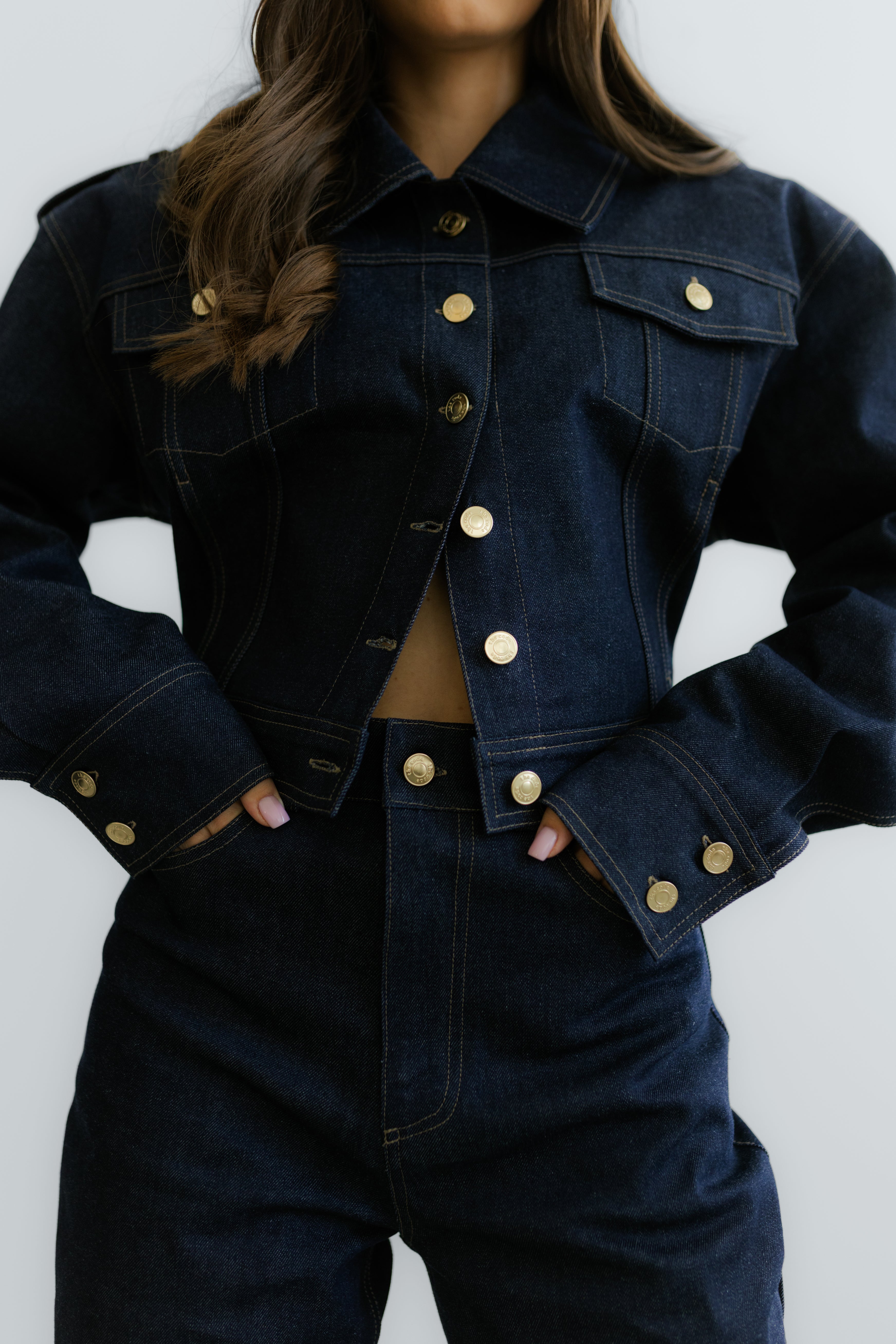 Granatowy denimowy komplet: Torino Jacket z wyraźnie zaznaczonymi ramionami i dopasowane Torino Jeans z wysokim stanem.