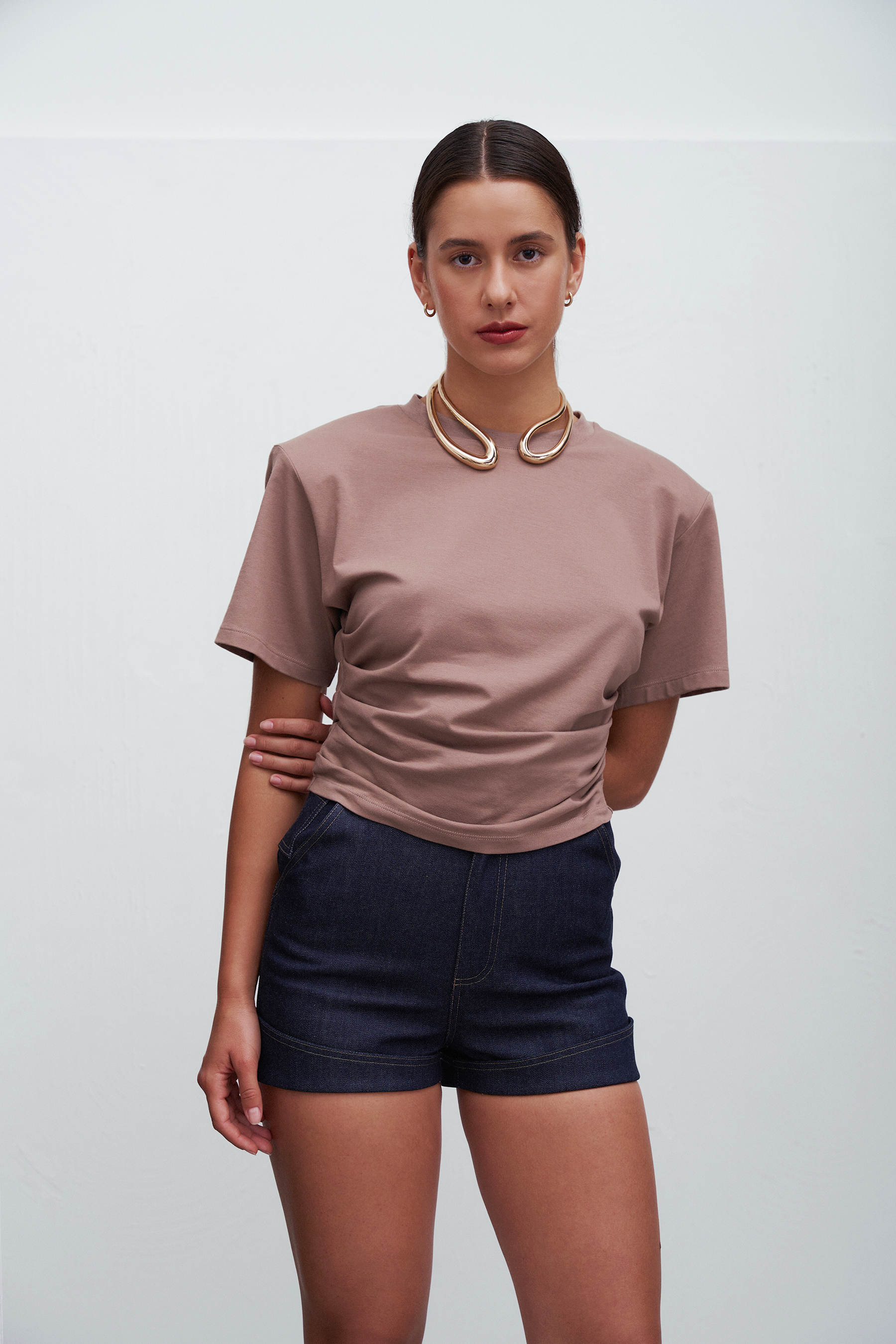 Damski T‑shirt Siena w kolorze taupe – klasyczny fason z poduszkami na ramionach i delikatnym marszczeniem w talii, idealny do minimalistycznych i stylowych codziennych stylizacji.