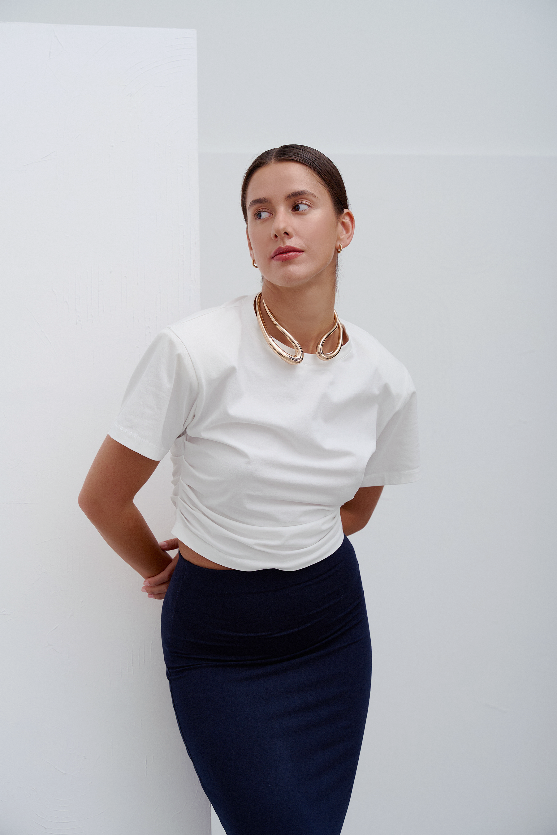 Biała Siena T‑shirt – klasyczny, minimalistyczny T‑shirt z wysokiej jakości bawełny z delikatnym detalem i komfortowym krojem, idealna baza do casualowych i modowych stylizacji.