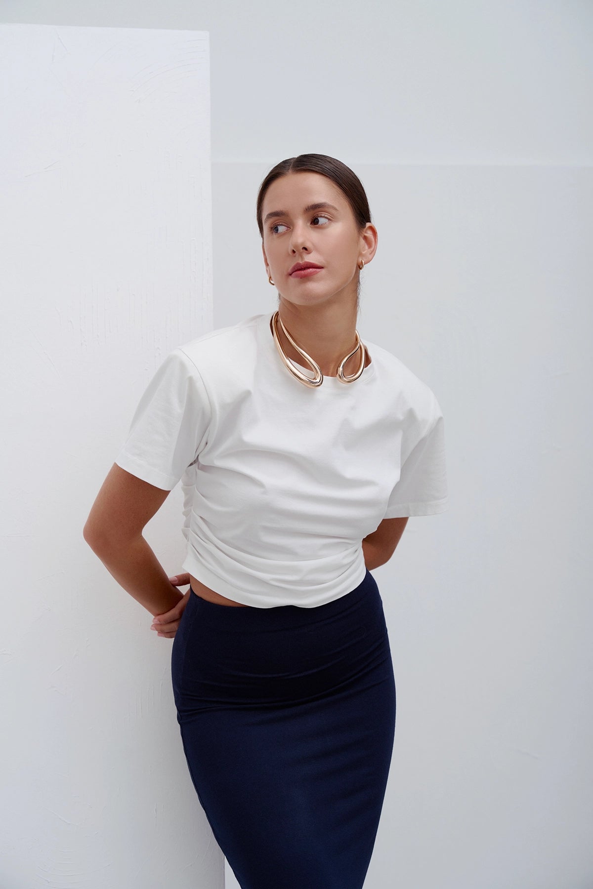 Biała Siena T‑shirt – klasyczny, minimalistyczny T‑shirt z wysokiej jakości bawełny z delikatnym detalem i komfortowym krojem, idealna baza do casualowych i modowych stylizacji.
