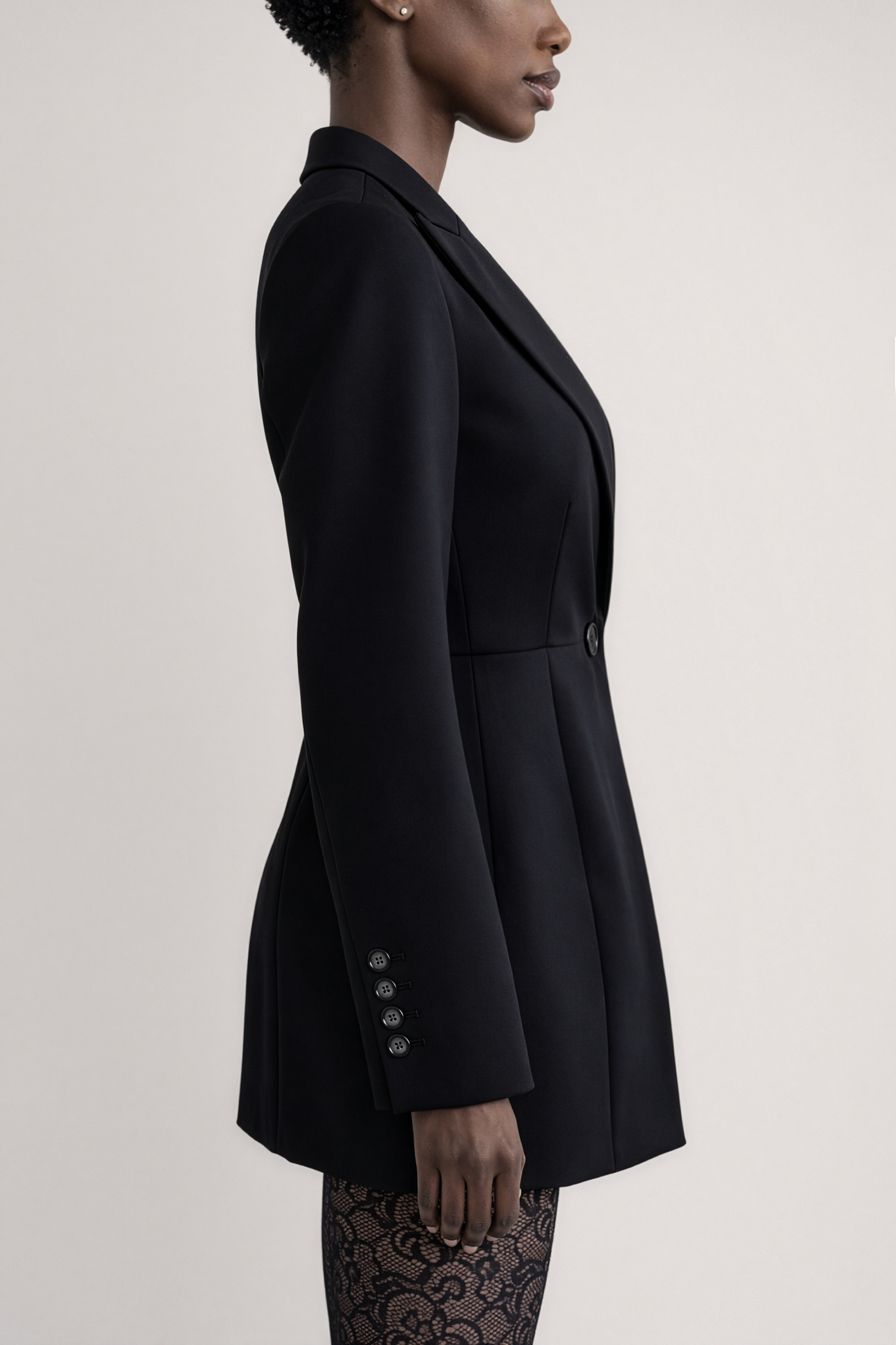 Lucca Blazer – czarny żakiet o nowoczesnym kroju z geometrycznymi ramionami, widoczny z boku.