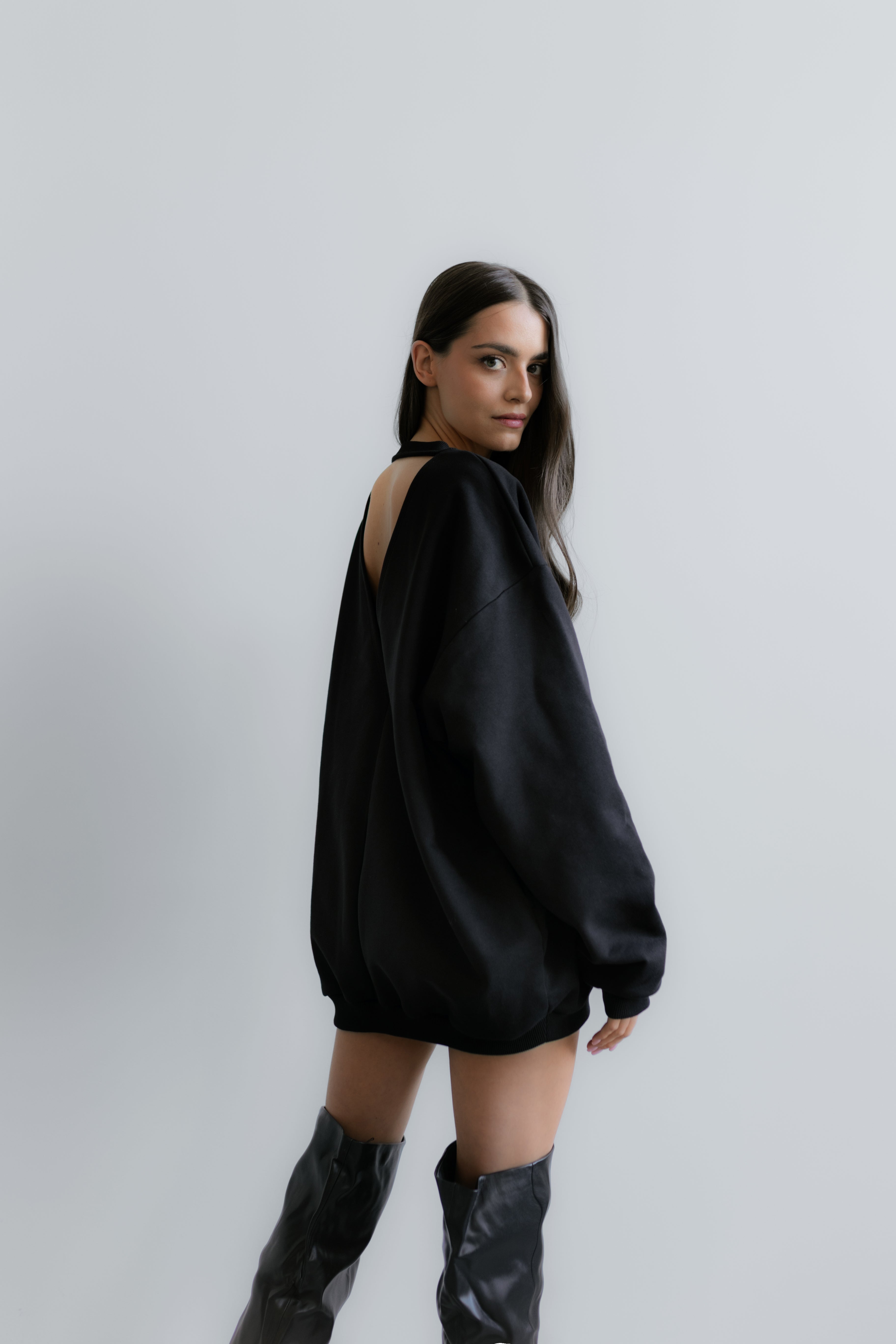 Czarna Milano Sweatshirt na modelce – showcasowe ujęcie z wyraźnym wycięciem z tyłu i minimalistycznym designem.