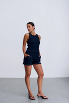 Riva Top Navy – dopasowany crop top damski z prążkowanej dzianiny w granatowym kolorze z geometrycznym wycięciem na plecach.