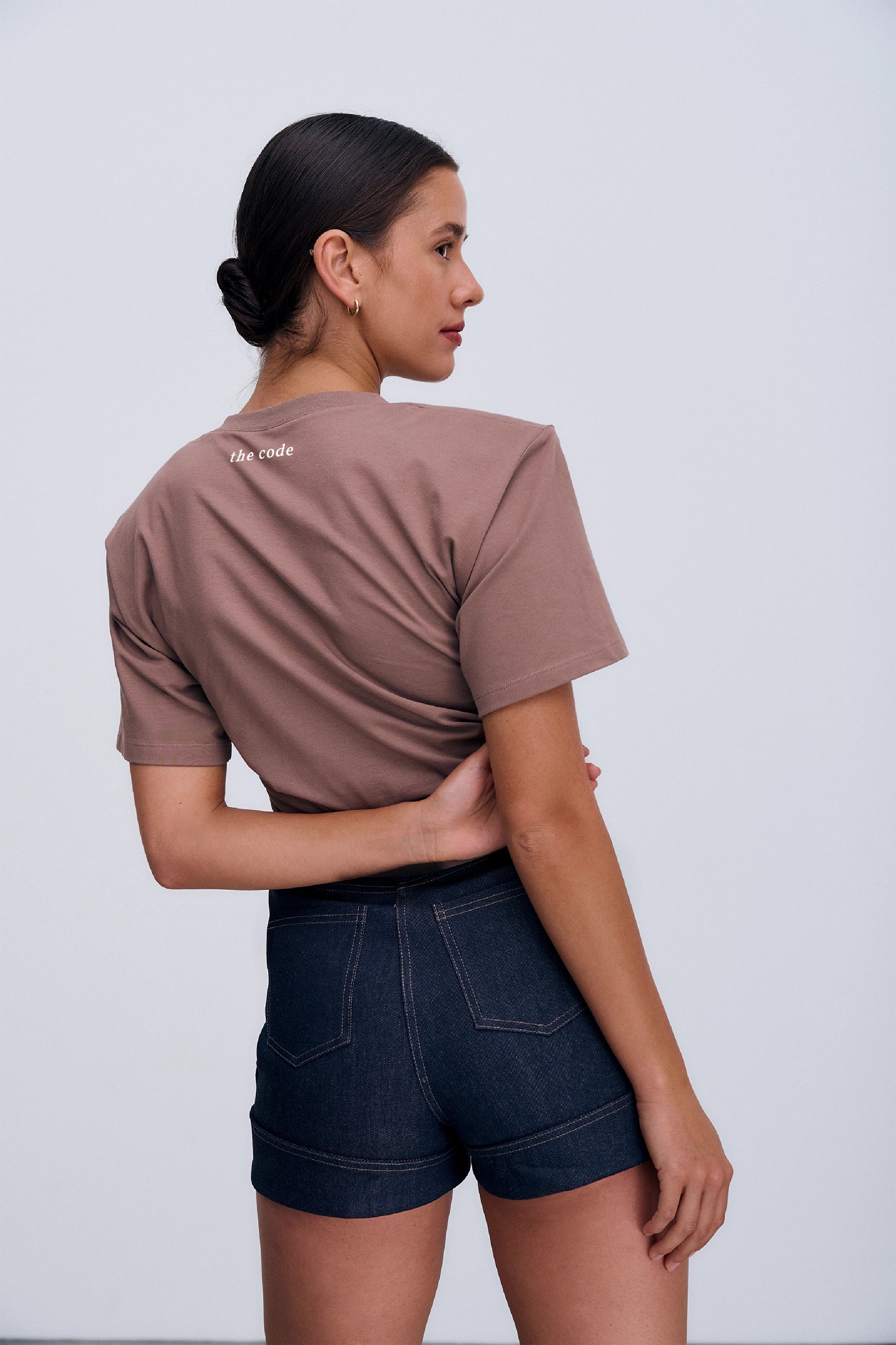 Tył Siena T‑shirt Taupe – krótki T‑shirt w odcieniu taupe, poduszki na ramionach i gładka bawełniana dzianina.