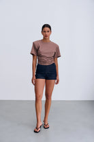 Siena T‑shirt Taupe – damski T‑shirt w kolorze taupe z okrągłym dekoltem, poduszkami na ramionach i subtelnym marszczeniem po bokach.