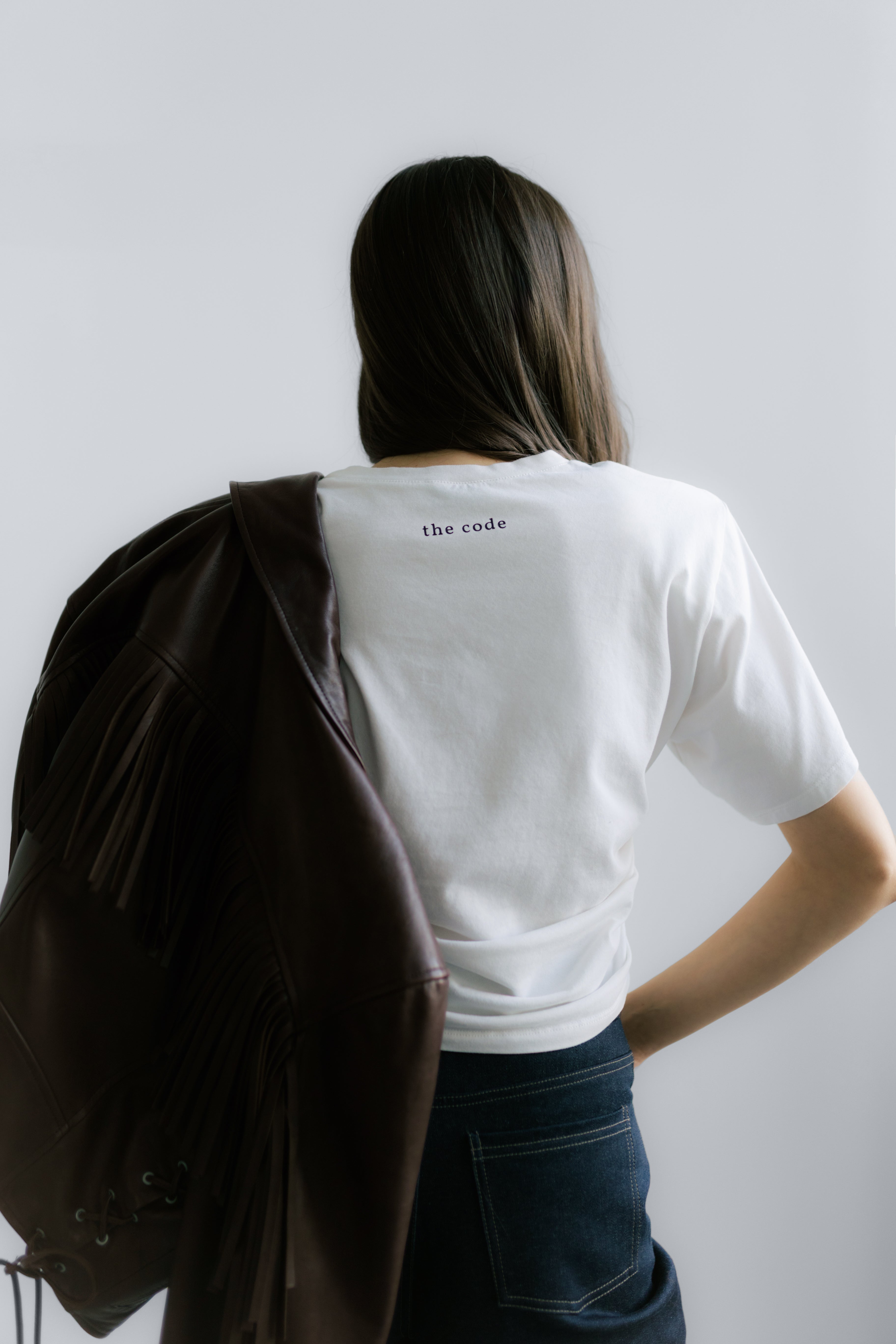 Tył Siena T‑shirt White – krótki biały T‑shirt z minimalistycznym logo i wyraźnymi poduszkami na ramionach.