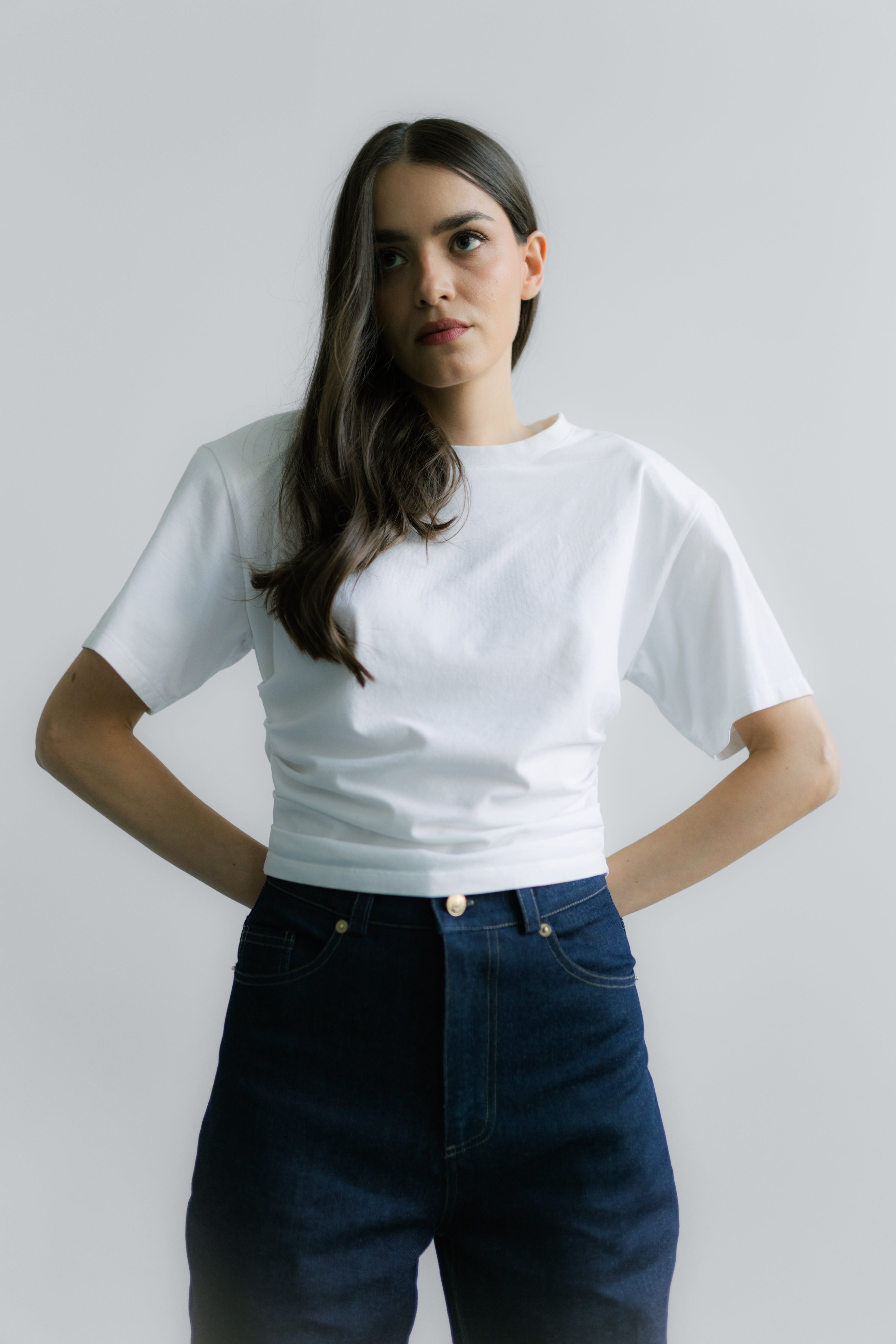 Minimalistyczny Siena T‑shirt White – krótki fason T‑shirtu z bawełnianej dzianiny z elastanem, subtelne logo z tyłu i strukturalne poduszki na ramionach.