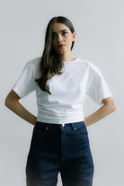 Minimalistyczny Siena T‑shirt White – krótki fason T‑shirtu z bawełnianej dzianiny z elastanem, subtelne logo z tyłu i strukturalne poduszki na ramionach.