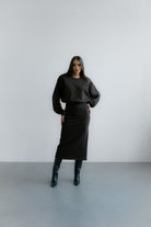 Modelka w Verona Sweatshirt – czekoladowa bluza oversize z poduszkami w ramionach i minimalistycznym, eleganckim wykończeniem.